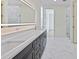 Bright bathroom featuring double vanity, white marble floors, and a large, illuminated mirror at 2894 Hardy Ave, New Smyrna Beach, FL 32168