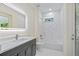 Modern bathroom with marble floors and shower, gray vanity, and illuminated mirror at 2894 Hardy Ave, New Smyrna Beach, FL 32168