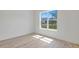 Bedroom with light wood floors, white walls, base trim, and a large window at 2894 Hardy Ave, New Smyrna Beach, FL 32168