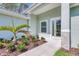 Welcoming front entrance showcasing a well-manicured garden and a modern glass-paneled door, creating a warm ambiance at 2894 Hardy Ave, New Smyrna Beach, FL 32168