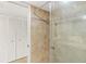 Bathroom featuring a glass shower stall, tile surround, and white louvered doors at 2987 S Atlantic Ave # 903, Daytona Beach, FL 32118