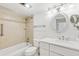 Well-lit bathroom with shower-tub combo, single sink vanity, and a decorative mirror at 2987 S Atlantic Ave # 903, Daytona Beach, FL 32118