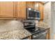 This kitchen offers stainless steel appliances, granite countertops, wood cabinetry, and tile backsplash at 2987 S Atlantic Ave # 903, Daytona Beach, FL 32118