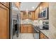 This kitchen offers stainless steel appliances, wood cabinetry, granite countertops, and tile backsplash at 2987 S Atlantic Ave # 903, Daytona Beach, FL 32118