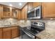 This kitchen offers stainless steel appliances, wood cabinetry, granite countertops, and tile backsplash at 2987 S Atlantic Ave # 903, Daytona Beach, FL 32118
