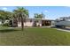 Single-story home with a carport and a boat in the driveway, surrounded by a green lawn at 3267 S Peninsula Dr, Daytona Beach, FL 32118