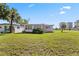 Inviting single-story home with a lush green lawn and tropical landscaping on a clear, sunny day at 3267 S Peninsula Dr, Daytona Beach, FL 32118