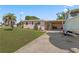 Single-story home features a carport, a boat in the driveway, and a well-maintained yard at 3267 S Peninsula Dr, Daytona Beach, FL 32118