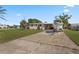 Cozy single-story home with a boat parked, featuring a spacious driveway and lush green surroundings at 3267 S Peninsula Dr, Daytona Beach, FL 32118