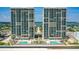 Stunning aerial view of two high-rise residential towers and dual sparkling swimming pools near a sandy beach at 3315 S Atlantic Ave # 1406, Daytona Beach Shores, FL 32118