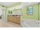 This bathroom features a granite countertop vanity and a soaking tub with a shower at 3315 S Atlantic Ave # 1406, Daytona Beach Shores, FL 32118