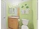 Powder room with wood vanity, toilet, and decor at 3315 S Atlantic Ave # 1406, Daytona Beach Shores, FL 32118