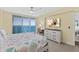 Bedroom featuring balcony access, dresser with TV, and a dedicated workspace at 3315 S Atlantic Ave # 1406, Daytona Beach Shores, FL 32118