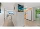 Hallway leading to a well-lit kitchen, featuring a bar with seating and a view of the ocean at 3315 S Atlantic Ave # 1406, Daytona Beach Shores, FL 32118