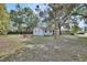 Spacious backyard featuring lush trees, a fire pit, and ample space for outdoor activities and entertaining at 352 Harlan Ave, Lake Helen, FL 32744