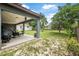 Spacious backyard featuring a covered patio area, lush greenery, and partial shade for outdoor enjoyment at 37 Naranja Rd, Debary, FL 32713