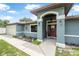 Inviting entryway with a decorative front door, arched entrance, and landscaped garden at 37 Naranja Rd, Debary, FL 32713