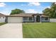 Charming single-story home featuring a two-car garage, well-maintained lawn, and inviting curb appeal at 37 Naranja Rd, Debary, FL 32713