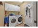 Functional laundry room equipped with a modern washer and dryer, cabinet storage, and neutral wall color at 37 Naranja Rd, Debary, FL 32713