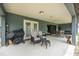Inviting covered patio featuring comfortable seating, a grill, and seamless access to the lush backyard at 37 Naranja Rd, Debary, FL 32713
