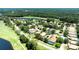 Gorgeous aerial view of the house surrounded by green golf courses, ponds, and lush trees at 438 Harbour Town Ln, Ormond Beach, FL 32174