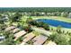 An aerial view of a home near a golf course, a lake, and lush landscaping at 438 Harbour Town Ln, Ormond Beach, FL 32174