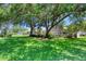Spacious backyard featuring mature trees, manicured lawn, and screened patio at 438 Harbour Town Ln, Ormond Beach, FL 32174