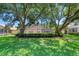 Beautiful backyard with large trees, green lawn, and an inviting screened patio at 438 Harbour Town Ln, Ormond Beach, FL 32174