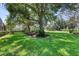 Lush backyard with mature trees, green lawn, and screened-in patio visible at 438 Harbour Town Ln, Ormond Beach, FL 32174