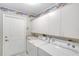 Laundry room with white cabinets, sink, and washer/dryer units with plenty of storage at 438 Harbour Town Ln, Ormond Beach, FL 32174