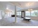 Open-concept living area with abundant natural light, a pillar, and modern chandelier at 438 Harbour Town Ln, Ormond Beach, FL 32174