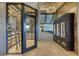 View of an elegant wine cellar with glass doors and a custom cabinet in a room with wood-look tile flooring at 438 Harbour Town Ln, Ormond Beach, FL 32174