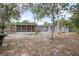 Landscaped backyard featuring a screened-in porch and a stone paver walkway at 45 S University Cir, Deland, FL 32724