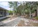 Spacious landscaped backyard featuring a stone paver walkway and mature trees at 45 S University Cir, Deland, FL 32724