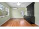 Comfortable bedroom featuring hardwood floors, windows, ceiling fan, and a large dresser at 45 S University Cir, Deland, FL 32724