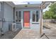 Exterior of home featuring a covered patio, air conditioning unit, and a peach entry door at 45 S University Cir, Deland, FL 32724