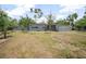 View of the front of the home that has a large yard, mature landscaping and decorative blocks at 45 S University Cir, Deland, FL 32724