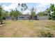 The one story house has a large front yard, mature landscaping and a decorative screen near the carport at 45 S University Cir, Deland, FL 32724