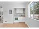 Cozy kitchenette area with white cabinets, oven and sink beneath a window at 45 S University Cir, Deland, FL 32724