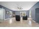 Living room with gray walls, tile floors, leather chairs, and access to the patio at 45 S University Cir, Deland, FL 32724