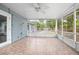 Large screened porch with tile flooring and ceiling fan, overlooking the backyard at 45 S University Cir, Deland, FL 32724