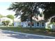 Charming blue single-story home with white trim, a well-manicured lawn, and a large shade tree in the front yard at 4611 Se 32Nd Pl, Ocala, FL 34480