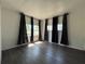 Bright living room features dark wood-look flooring and black and silver curtains at 487 Collins St, Ormond Beach, FL 32174