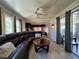 Open concept living room featuring a ceiling fan, dark leather couch, and light wood floors at 487 Collins St, Ormond Beach, FL 32174