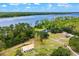 Aerial view showcasing the expansive property with a house, barn, and lakefront surrounded by dense forest at 5366 N Lake Farms Rd, De Leon Springs, FL 32130