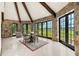Charming dining room featuring stone walls, beamed ceilings, tile floors, and picturesque backyard views at 5366 N Lake Farms Rd, De Leon Springs, FL 32130