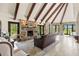 Inviting living room with a stone fireplace, beamed ceilings, tile floors, and panoramic views of the backyard at 5366 N Lake Farms Rd, De Leon Springs, FL 32130