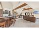 Open-concept living area with a bar, wooden beams, a leather sofa, and a unique ceiling design at 5366 N Lake Farms Rd, De Leon Springs, FL 32130