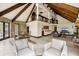 Spacious living room with beamed ceilings, stone accents, tile floors, and abundant natural light from the backyard at 5366 N Lake Farms Rd, De Leon Springs, FL 32130