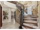 Elegant staircase with stone walls, tile steps and decorative iron railing at 5366 N Lake Farms Rd, De Leon Springs, FL 32130